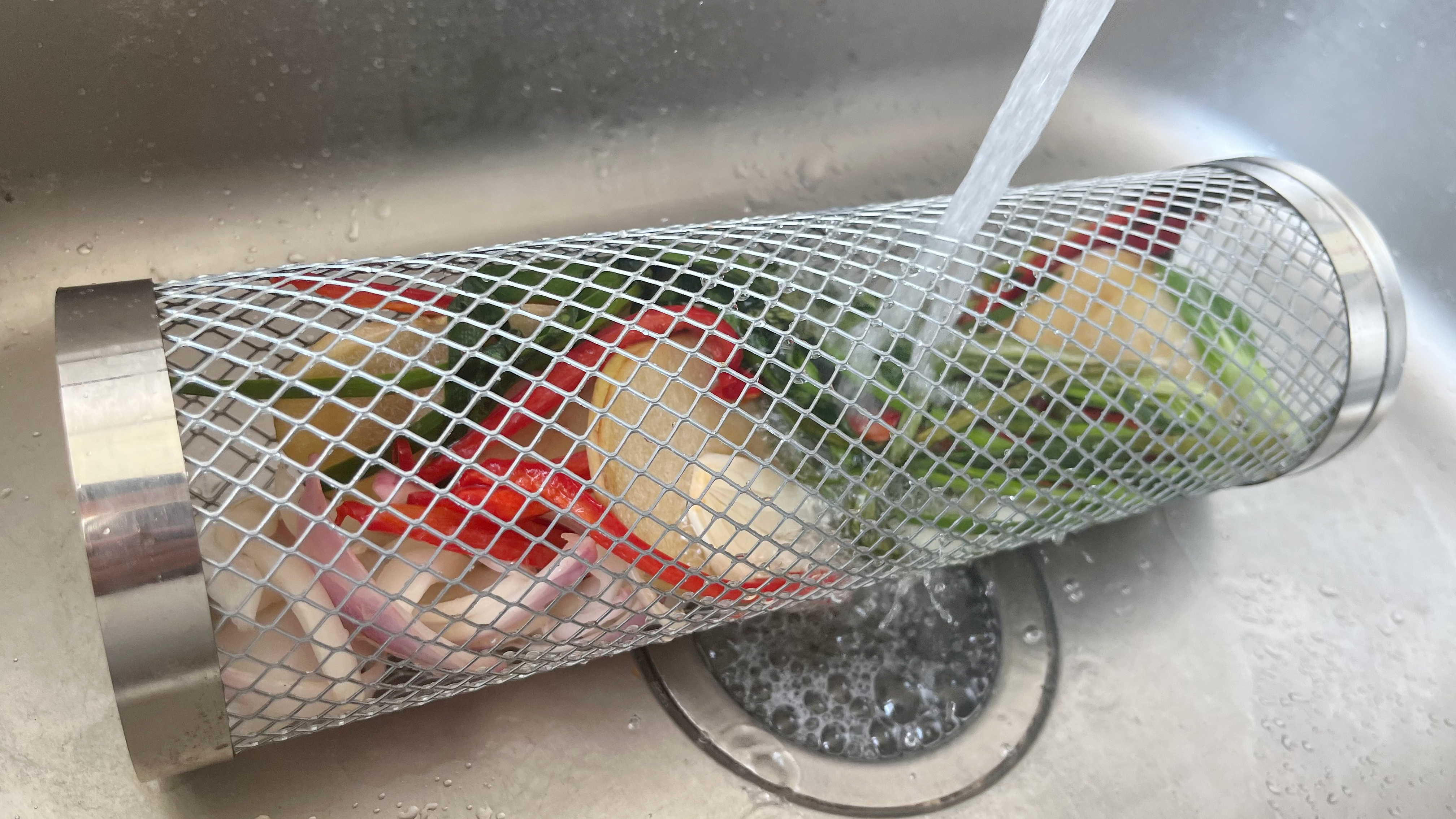 Close-up of the Grill Well 2.0 stainless mesh being cleaned